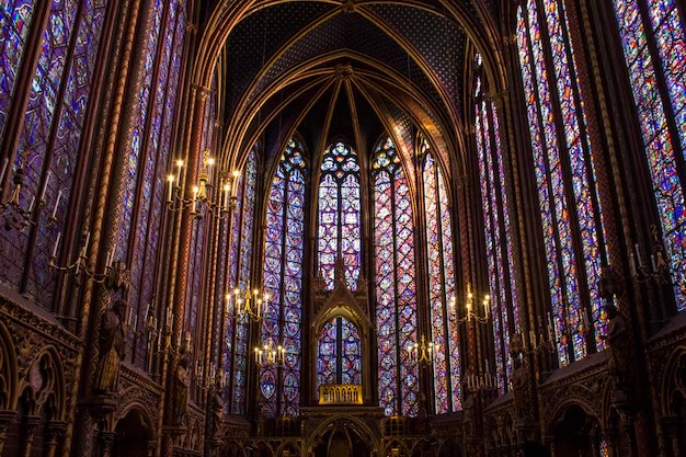 نمای داخلی یک کلیسای جامع با سقفهای بلند ضربی، لوسترهای شمعی روشن و دیوارهای پوشیده شده از پنجرههای عظیم با شیشههای رنگی (Stained Glass) که نوری عرفانی ساطع میکنند.